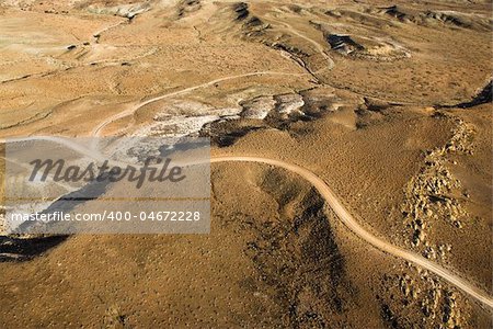 Aerial view of a of rural, desert landscape with a road running through it. Horizontal shot.