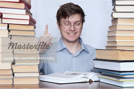 Young happy student show finger to up between books