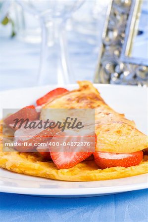 Omelette with sliced fresh strawberries on plate