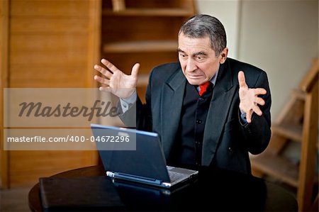 Shocked businessman working on a laptop