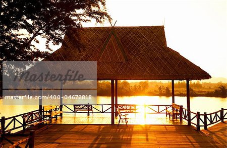 Yellow sunset over the summerhouse on the river