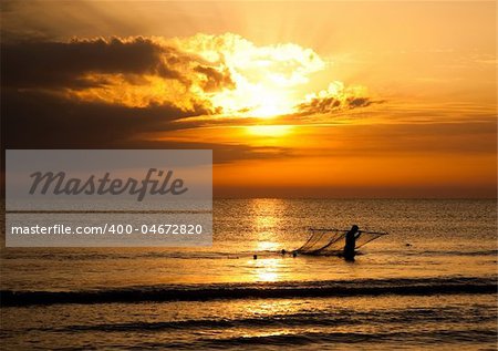 Silhouette Of Fisherman On The Sunrise Background