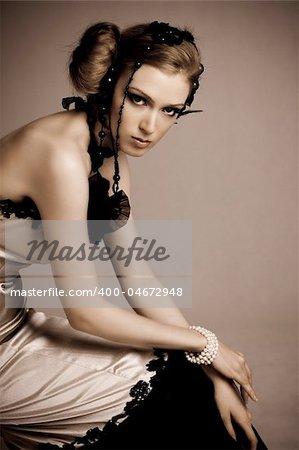 Attractive young woman wearing an evening gown of black lace and white satin. Vertical shot.