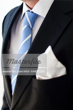 Groom wearing dark suit and a blue tie.