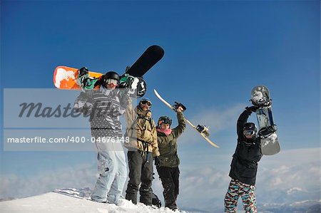 young snowboarders group have fun and relax at sunny winter day on winter season