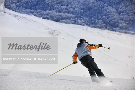 skier free ride downhill at winter season on beautiful sunny day