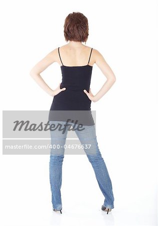 Cute young adult caucasian woman wearing a black top and jeans and with short brunette hair on a white background. Not Isolated