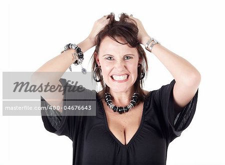 Cute young adult caucasian woman wearing a black outfit and a beaded necklace with black boots and brunette hair standing frustrated with her hands in her hair on a white background. Not Isolated