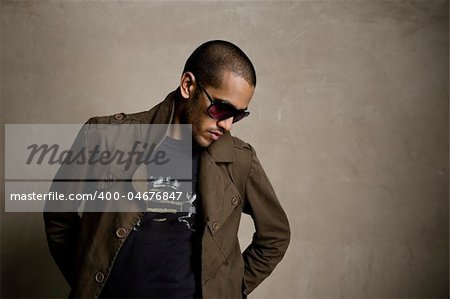 Fashion model blends in with the grunge wall behind him