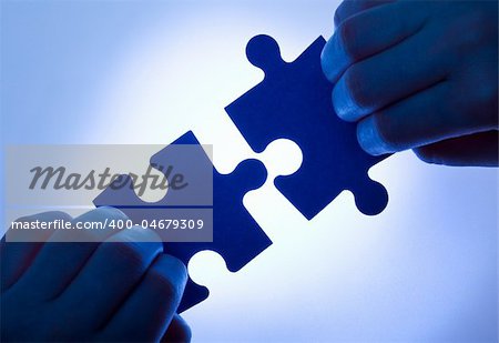 Business values - teamwork and collaboration concept with low key hands and puzzle pieces