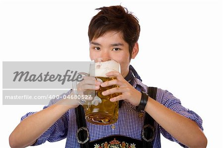 Asian man holding an Oktoberfest beer stein and drinks out of it. Isolated on white background.