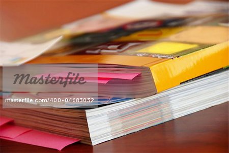 two dense catalogs with bookmarks closeup on desk