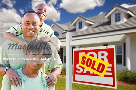 Happy and Attractive African American Family with Sold For Sale Real Estate Sign and House.