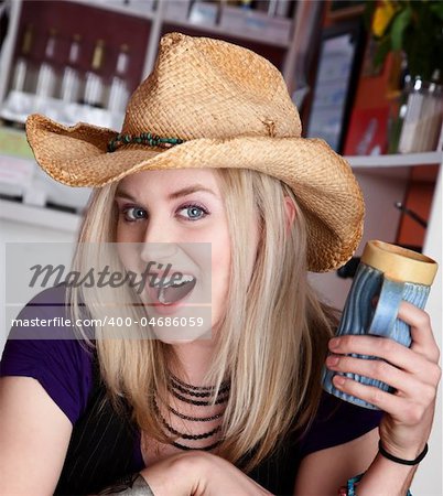 Young blond girl with cowboy hat and coffee