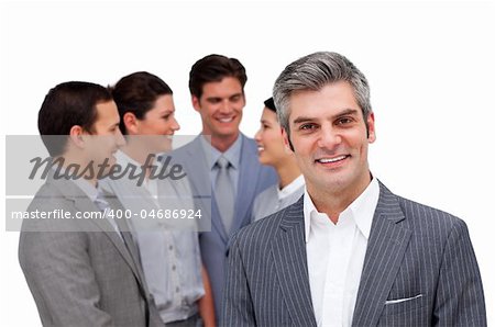 Mature manager standing with his team against a white background