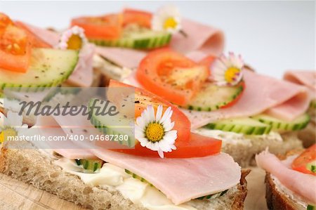 Healthy spring sandwiches with ham, tomato, cucumber and cream cheese seasoned with freshly ground pepper