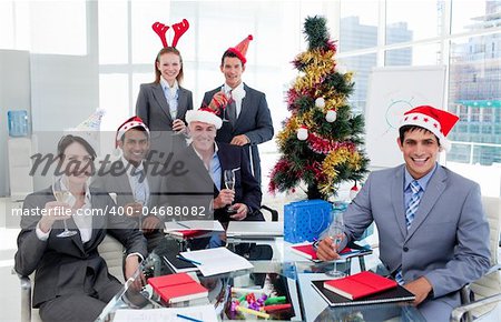 Portrait of a happy business team toasting with Champagne at a Christmas party in the office