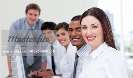 Cheerful business team working at computers in a company