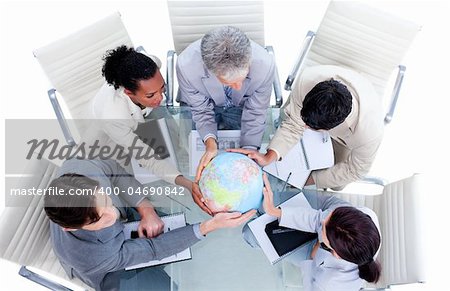 Serious international business team holding a terrestrial globe in a meeting