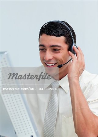 Latin businessman talking on headset at work