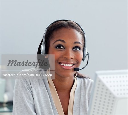 Delighted businesswoman using headset at her desk in the office