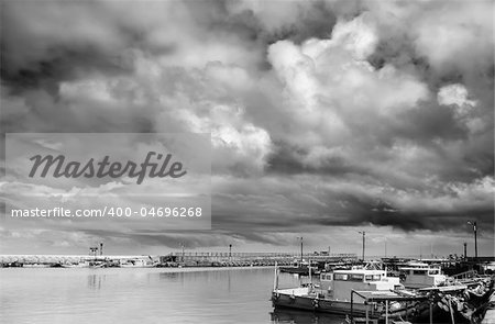 Nature scenic of storm clouds with boats on harbor.
