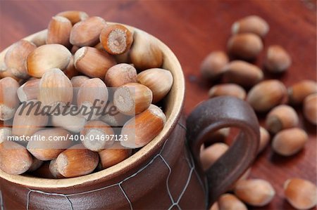 Hazelnuts in a ceramic mug and on wooden table