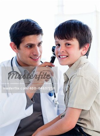 Charming doctor examining little boy's ears at the practice