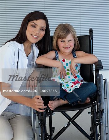 Cute girl sitting on a wheelchair with a female doctor in the hospital