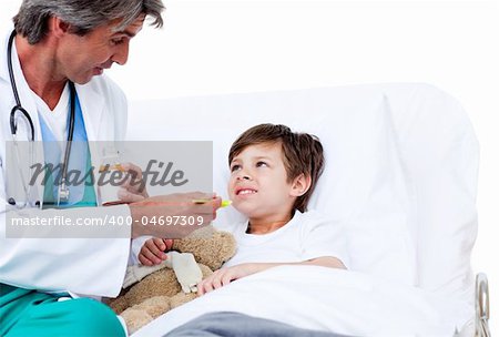 Cute little boy taking cough medicine in hospital