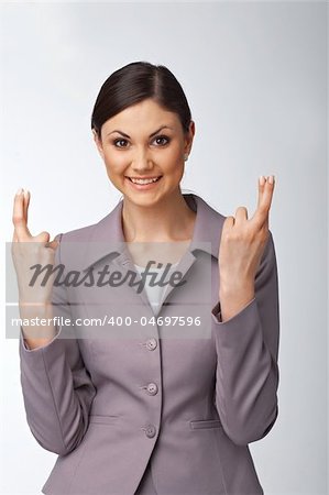 Portrait of a happy young business woman with fingers crossed