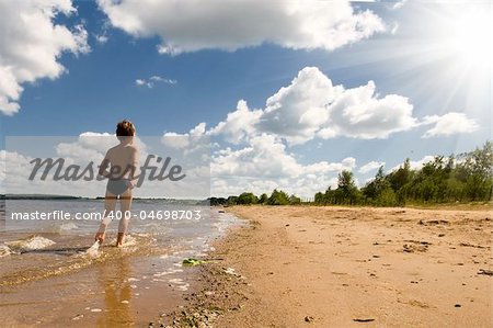 young boy running at the beautiful beach of river