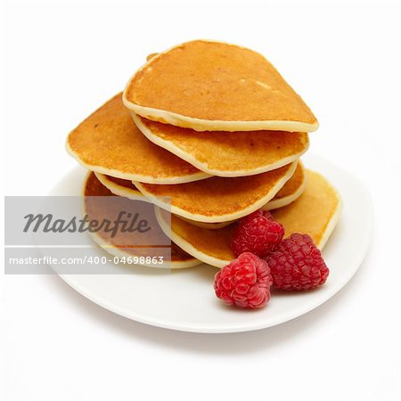 small pancakes topped with berries isolated on white