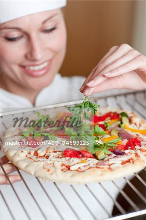 Charming female chef preparing a pizza in the kitchen