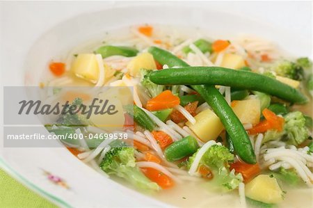 Delicious vegetable soup with carrot, potato, broccoli, green beans, parsley and noodles