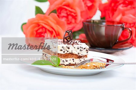 Sweet chocolate dessert with nuts, rose and cup of coffee