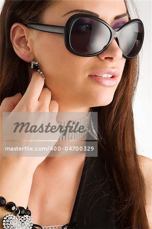 closeup portrait of pretty brunette with long dark hair sunglasses and jewellery