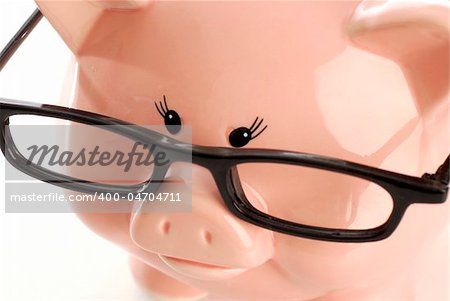 pink piggy bank wearing black rimmed glasses on white background