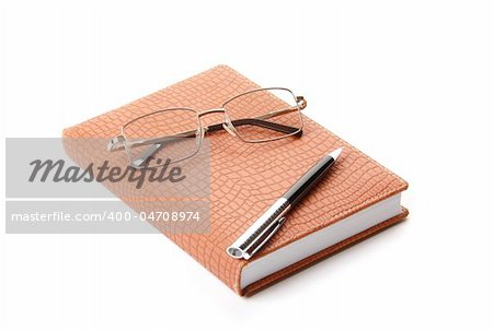 Datebook, pen and glasses. Isolated on white