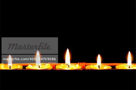 row of candles on black background