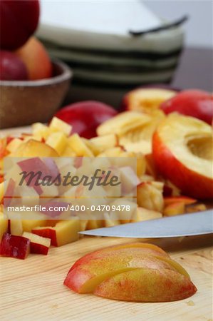 Halved and chopped nectarines on a cutting board for jam making