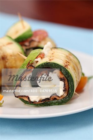 Grilled zucchini rolls with pepper crusted bacon and cheese. Shallow DOF