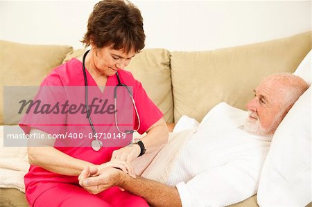 Home health nurse taking the pulse of an elderly patient.