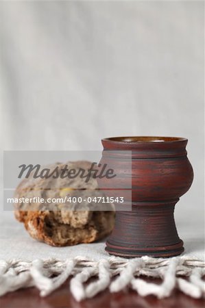 Chalice with wine and bread in background. Shallow dof, copy space