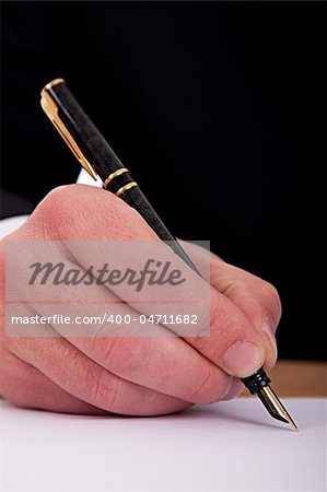 businessman signing a document  with a fountain pen isolated on a white background. Studio shot