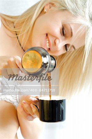 The portrait of a beautiful girl. Pours coffee. Isolated picture.