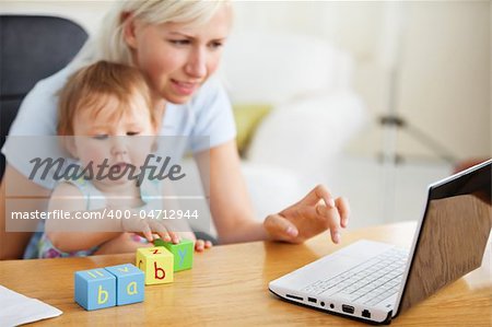 Positive family using laptop and playing with toys in the living-room