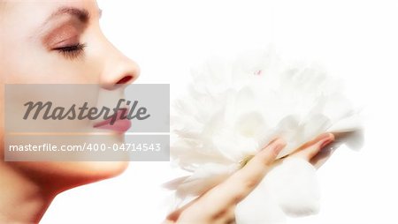 Beautiful woman smeling a white flower.