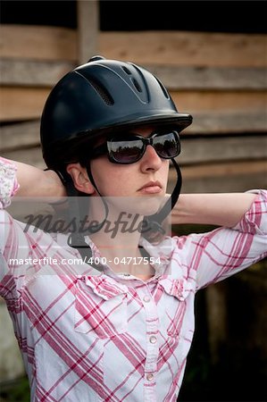 Female Costa Rican tourist putting on equestrian helmet