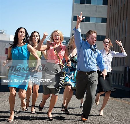 Happy men and women running down the street.